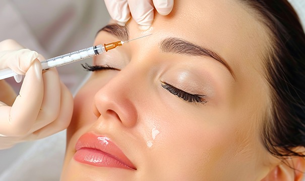 Woman receiving BOTOX injection between her eyebrows