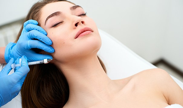 Woman receiving dermal filler injection in her jawline