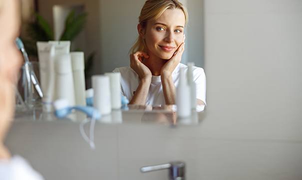 Woman smiling at herself in mirror